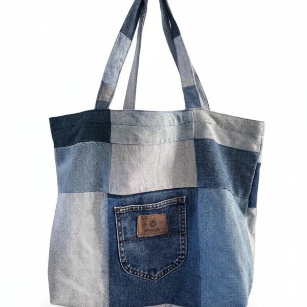 A patchwork tote bag made from panels of different shades of reclaimed denim