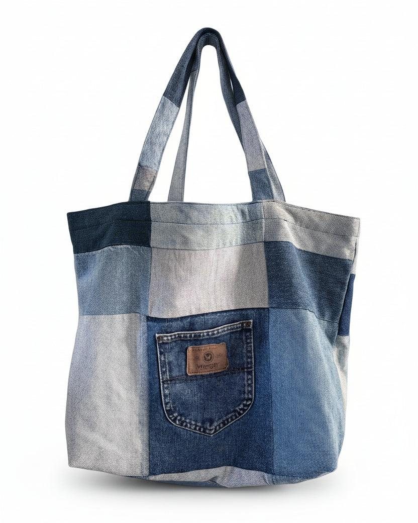 A patchwork tote bag made from panels of different shades of reclaimed denim